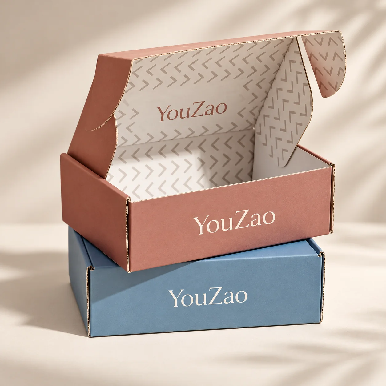 Stacked corrugated clothing mailer boxes with blue and patterned interior artwork