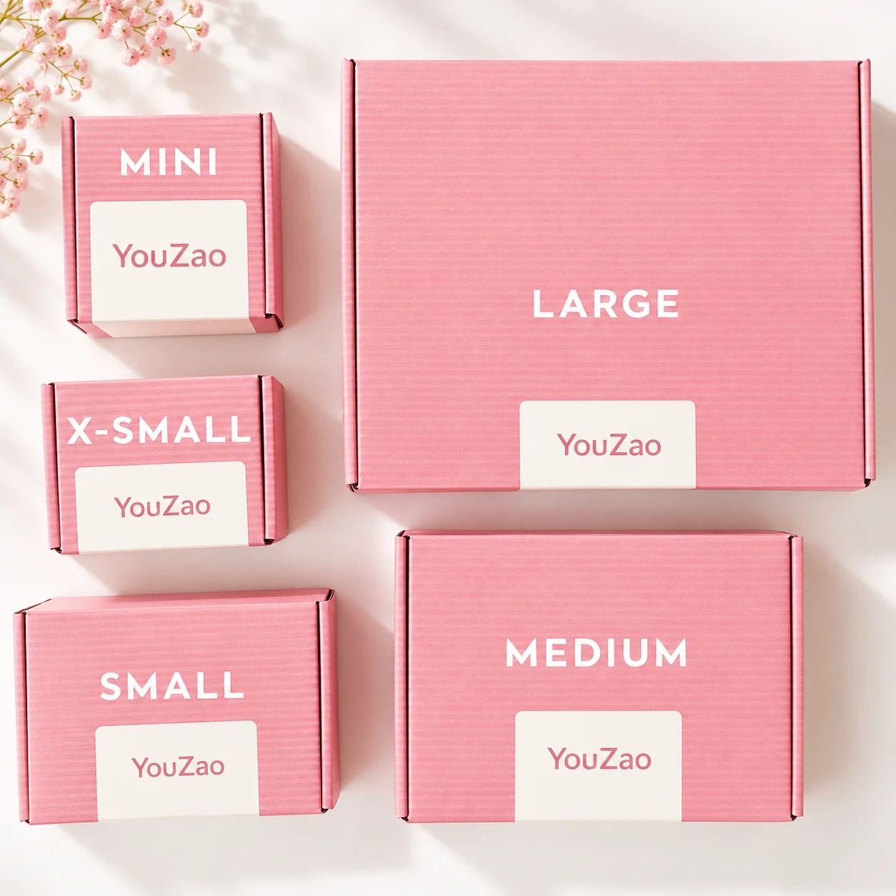 Pink corrugated clothing mailer boxes in five illustrated size formats