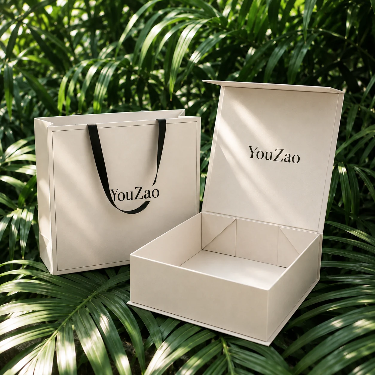 Open ivory gift box with matching paper bag and black handles